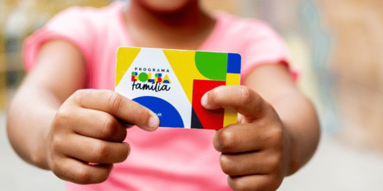 Criança segurando o cartão do programa Bolsa Família.