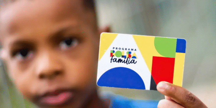 Criança segurando o cartão do programa Bolsa Família.