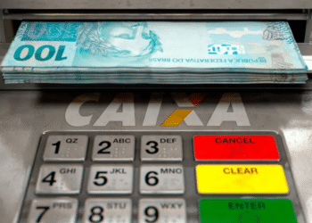 Notas de 100 reais sendo retiradas de um caixa eletrônico da CAIXA.