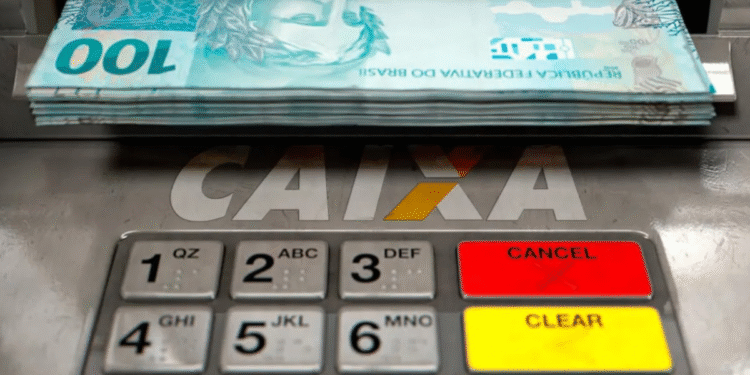 Notas de 100 reais sendo retiradas de um caixa eletrônico da CAIXA.