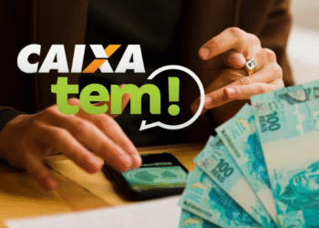 Pessoa usando o aplicativo Caixa Tem no celular com notas de 100 reais ao lado.