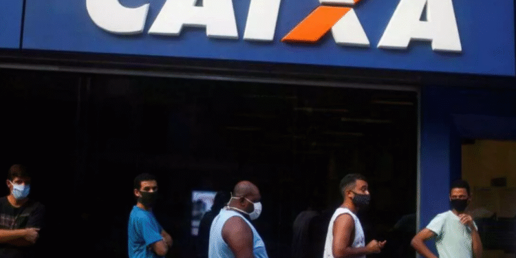 Pessoas em fila em frente a uma agência da Caixa Econômica Federal.
