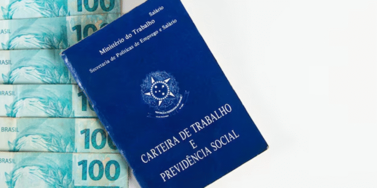 Carteira de Trabalho sobre notas de 100 reais, simbolizando benefícios trabalhistas.