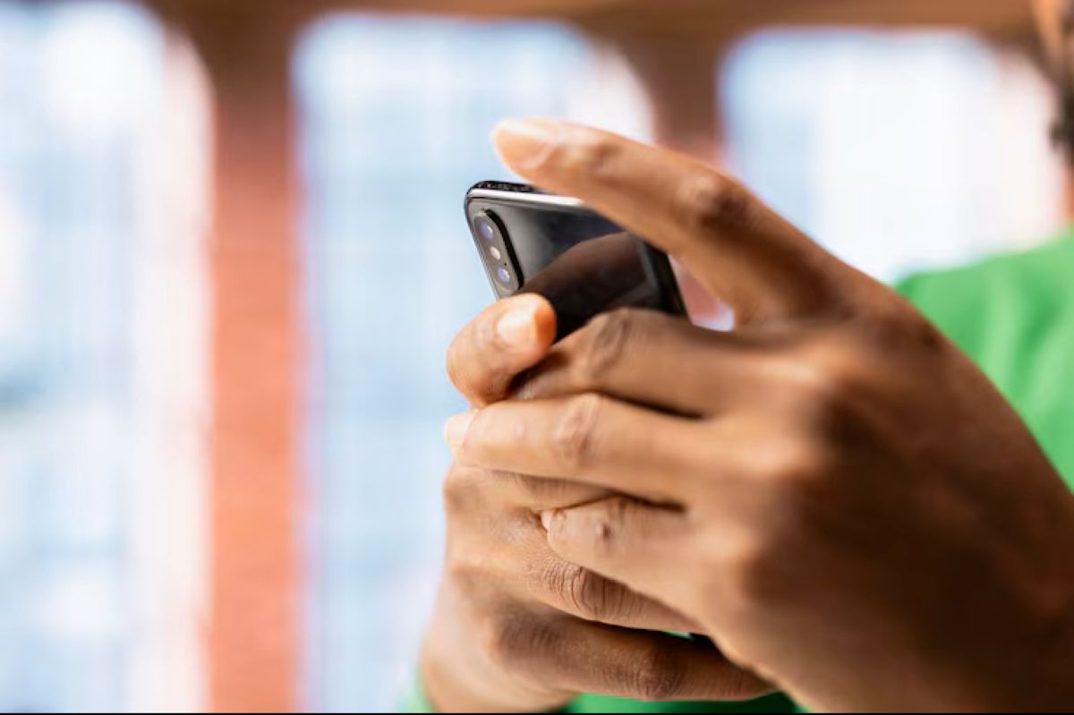 Mãos de uma pessoa usando um celular para acessar a internet, representando a consulta digital ao Sistema de Valores a Receber (SVR) do Banco Central.