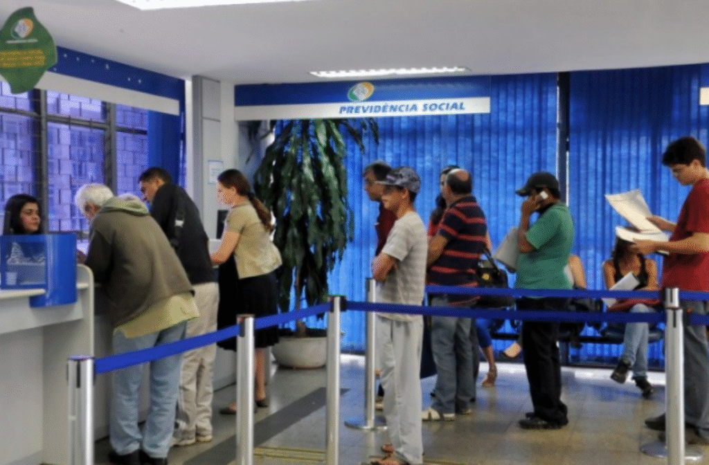 Pessoas em fila na agência da Previdência Social aguardando atendimento.