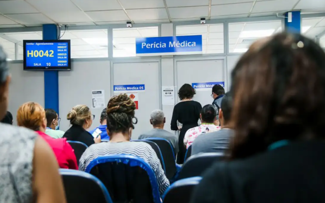 Pessoas aguardam atendimento em fila para perícia médica do INSS durante mutirão de atendimentos.