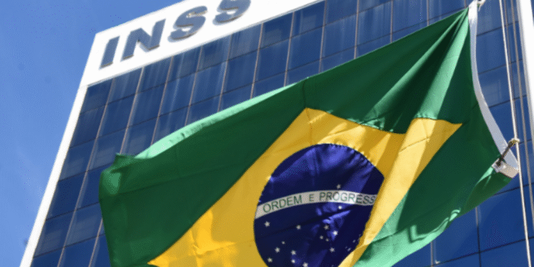 Fachada do prédio do INSS com bandeira do Brasil ao vento.