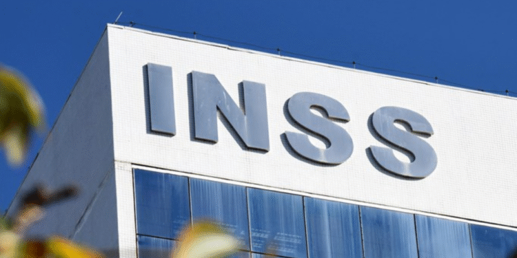 Letreiro do INSS em fachada de prédio com céu azul ao fundo