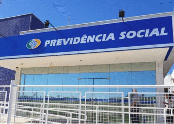 Fachada da agência da Previdência Social com placa azul e letreiro branco.
