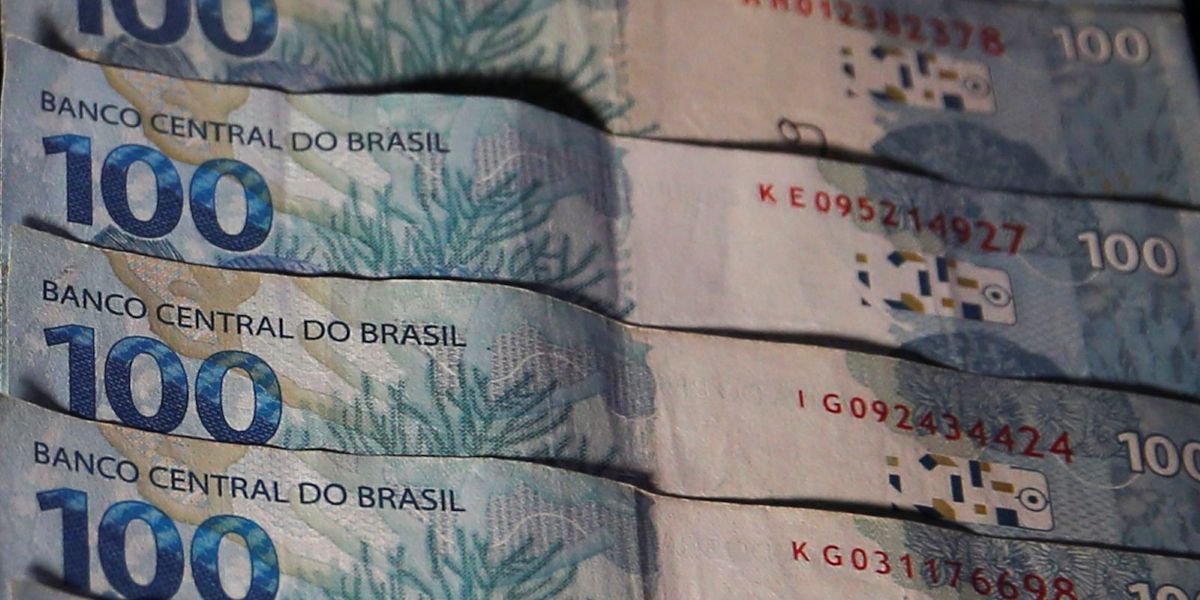 Pilha de notas de R$ 100 reais, representando o montante financeiro dos valores a receber que podem ser consultados no Banco Central por meio do SVR.
