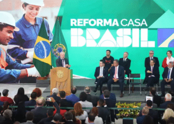 Presidente Lula em evento do programa Reforma Casa Brasil, com imagem de trabalhadores da construção civil ao fundo, simbolizando a execução das obras e o benefício direto à população.