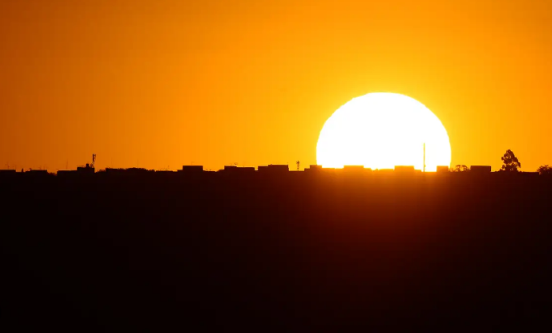 Pôr do sol com céu alaranjado simbolizando o debate sobre o horário de verão no Brasil.
