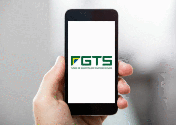 Celular na mão exibindo logotipo do FGTS - Fundo de Garantia do Tempo de Serviço