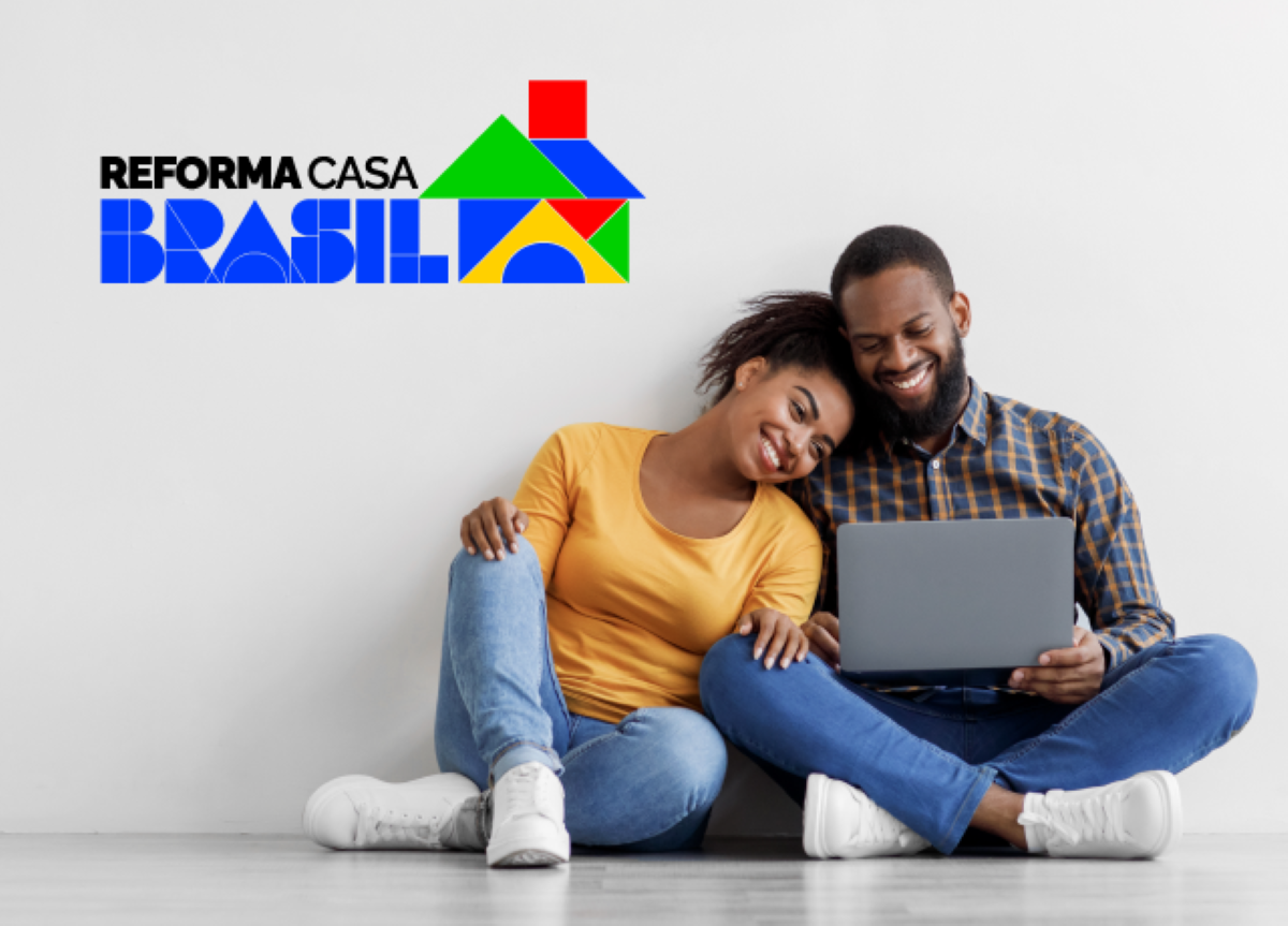 Reforma Casa Brasil: Desvendando o Caminho para a Liberação do seu Crédito Casal feliz sentado no chão com um notebook, com o logo 'Reforma Casa Brasil', representando a facilidade de solicitar e a expectativa pela liberação do crédito habitacional.