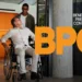 Imagem de um idoso em cadeira de rodas, sendo ajudado por um jovem, com destaque para o logo do BPC (Benefício de Prestação Continuada) em 2026.