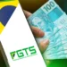 Mão segurando cédulas de 100 reais e celular com logo do FGTS e bandeira do Brasil