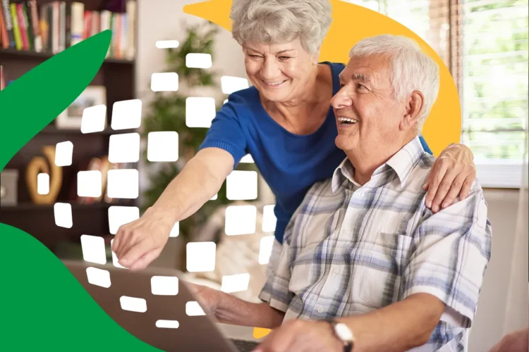 Inclusão do INSS online para idosos em 2026. Casal de idosos sorridente utiliza notebook juntos em casa com a imagem do INSS ao fundo.