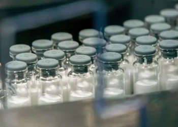 Frascos de vacina alinhados em ambiente de produção industrial