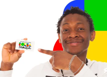 Homem sorridente aponta para cartão do Bolsa Família diante de fundo colorido