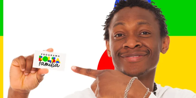 Homem sorridente aponta para cartão do Bolsa Família diante de fundo colorido