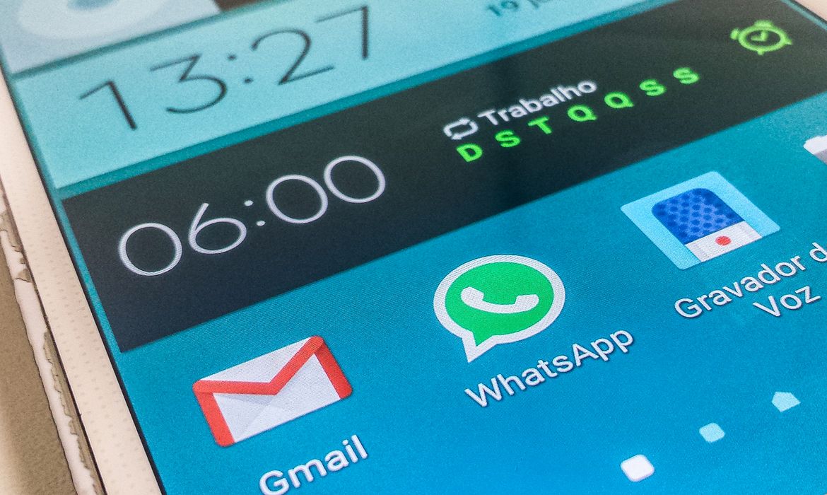 Tela inicial de smartphone com aplicativos de comunicação abertos Tela de smartphone exibindo ícones do Gmail, WhatsApp e Gravador de Voz ao lado do relógio