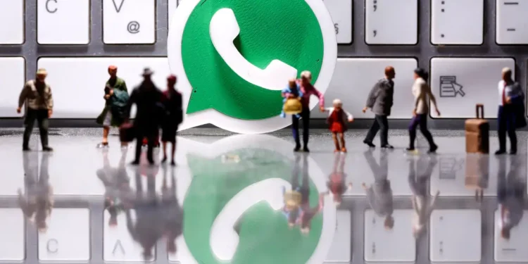 Miniaturas de pessoas caminhando diante de ícone do WhatsApp sobre teclado de computador