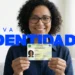 Mulher segura Carteira de Identidade nova em casa, sorrindo, com texto azul "Nova Identidade" na imagem.