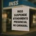 Cartaz branco com letras grandes anuncia suspensão do atendimento presencial no INSS durante o Carnaval