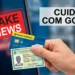 Mão segura cartão de banco e RG diante de celular exibindo aviso de fake news.