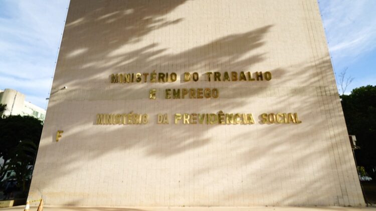 Nova regra 2026 Parede do Ministério do Trabalho e Emprego com letreiro dourado sob sombra de árvores