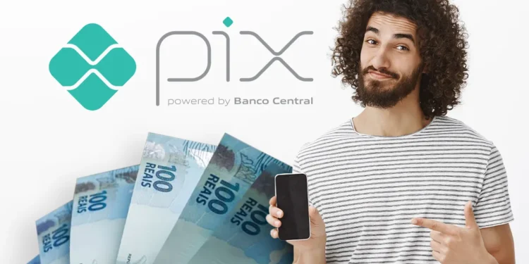 Homem sorrindo aponta para celular ao lado de notas de R$ 100 e logotipo do Pix.