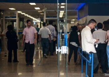 Pessoas entrando e saindo de agência bancária — bancos fechados no feriado de Páscoa Sexta-feira Santa 2026