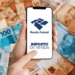 Dedo apontando para celular com aplicativo da Receita Federal aberto entre cédulas de reais