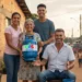 Família sorridente entrega botijão do Gás do Povo a idosa em vila simples