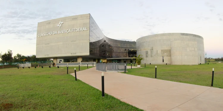 Prédio moderno do Conselho da Justiça Federal com fachada espelhada e gramado amplo