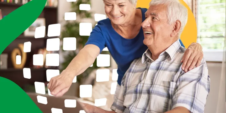 Idosos sorrindo consultam notebook juntos em ambiente doméstico