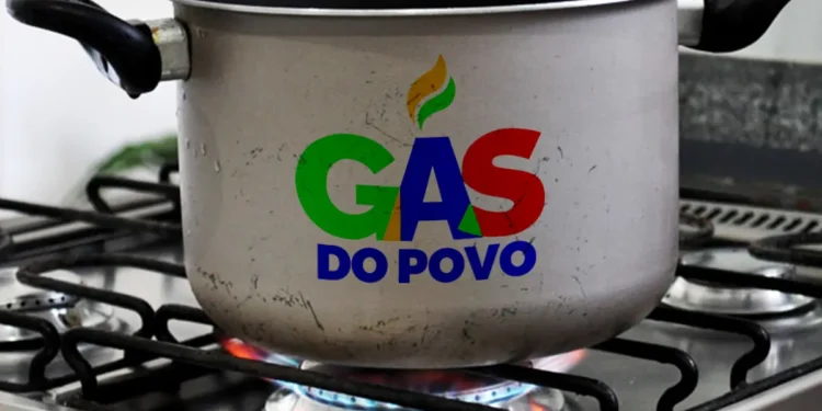 Panela com logo Gás do Povo sobre chama de fogão acesa em cozinha