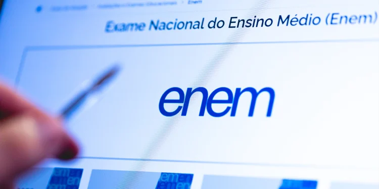 Tela do site oficial do Enem com logo azul e texto “Exame Nacional do Ensino Médio” apontada por caneta.