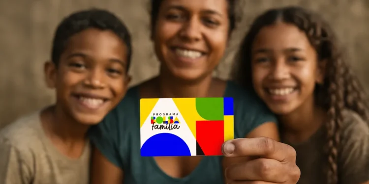 Mãe e filhos sorrindo, segurando o cartão do Programa Bolsa Família, com fundo neutro.