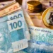 Cédulas de real e moeda de R$ 1 dispostas sobre mesa, ilustrando o pagamento do lote residual de restituição do Imposto de Renda liberado pela Receita Federal em abril de 2026.