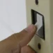 Mão aciona interruptor de luz, representando o acesso ao desconto na tarifa de energia elétrica pelo programa Luz do Povo para famílias de baixa renda em 2026.