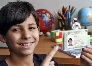 Criança sorrindo e segurando a nova Carteira de Identidade Nacional, representando a emissão gratuita da CIN em Salvador em abril de 2026.
