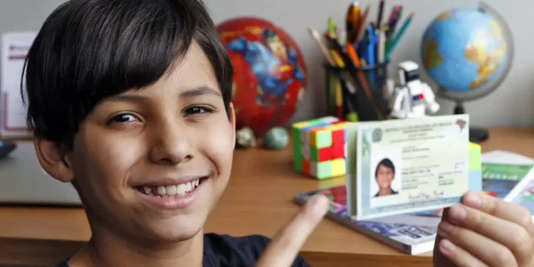 Criança sorrindo e segurando a nova Carteira de Identidade Nacional, representando a emissão gratuita da CIN em Salvador em abril de 2026.