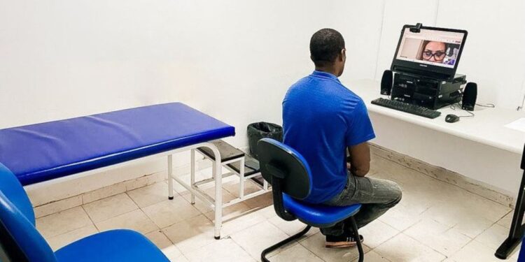 Segurado realiza teleperícia do INSS em sala com computador e atendimento remoto-