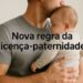 Pai segurando bebê recém-nascido no colo e beijando sua cabeça com texto nova regra da licença-paternidade sobreposto