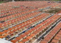 Vista aérea de conjunto habitacional com centenas de casas padronizadas do Minha Casa Minha Vida sob as novas regras de 2026