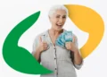 Uma mulher idosa sorridente, piscando e fazendo sinal de positivo com as duas mãos. Ela segura várias cédulas de 100 reais, simbolizando a satisfação com o recebimento do benefício do INSS.