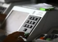 Urna eletrônica da Justiça Eleitoral sendo operada por eleitor, simbolizando a importância de regularizar o título antes do prazo de 6 de maio para votar em outubro de 2026
