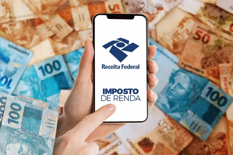 Mão segurando smartphone com tela do app Receita Federal e logo Imposto de Renda sobre cédulas de 50 e 100 reais.