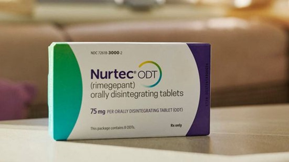 Caixa do medicamento Nurtec ODT de 75mg com rimegepant para enxaqueca, cores verde, branca e roxa